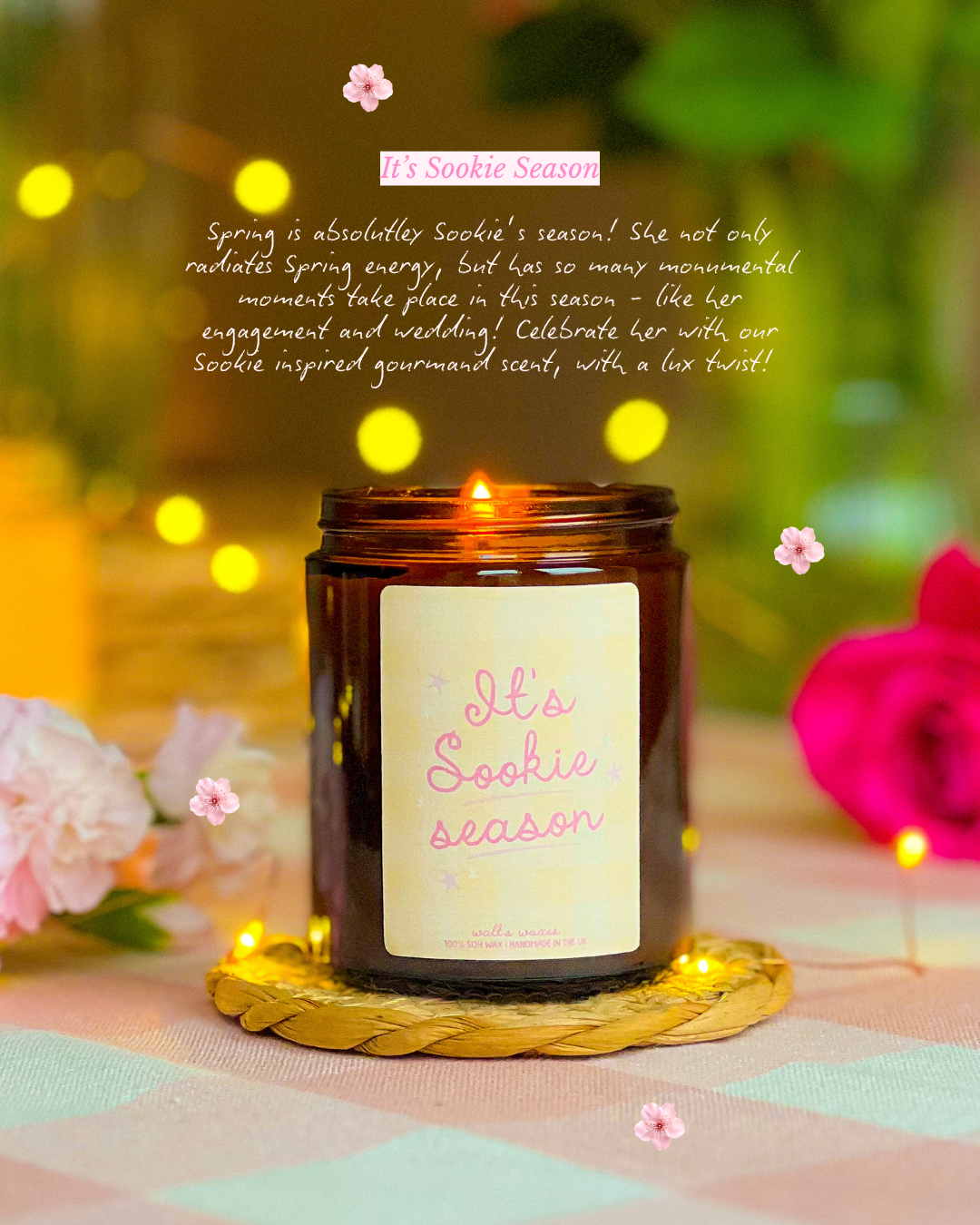 Candle with 'It's Sookie Season' label on a decorative surface with flowers and lights.